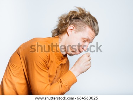 Handsome man coughs, isolated on background