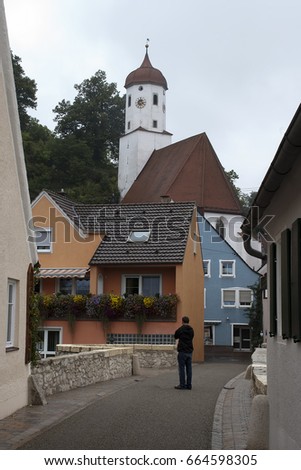 Harburg Germany, street scene with man on old stone bridge and church in background