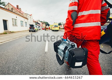 Hand of the doctor with defibrillator. Teams of the Emergency medical service are responding to an traffic accident. Royalty-Free Stock Photo #664615267