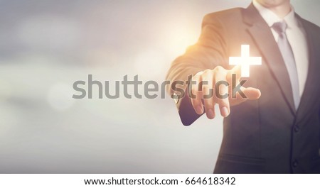 Businessman touching plus sign positive thing, such as benefits, profit, development, CSR, copy space Royalty-Free Stock Photo #664618342