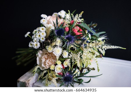 Wedding bouquet in Boho style on a black background. A bunch of fresh wildflowers