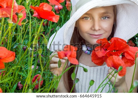 Cute child girl in poppy field. Happy child girl in poppy field. Girl in poppies. Spring.