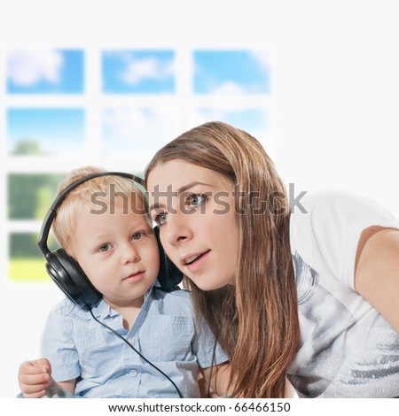 Portrait of young mother and her son listening music.