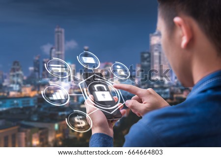 The abstract image of business man point to the hologram on his smartphone and blurred cityscape is backdrop. the concept of communication network cyber security internet of things and internet. Royalty-Free Stock Photo #664664803