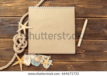 Shells and notepad on wooden table. Top view with copy space