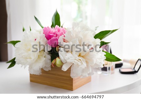 Beautiful bouquet with fragrant peonies on dressing table