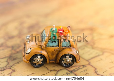 Miniature ,businesses team sitting on car for travel around the world.