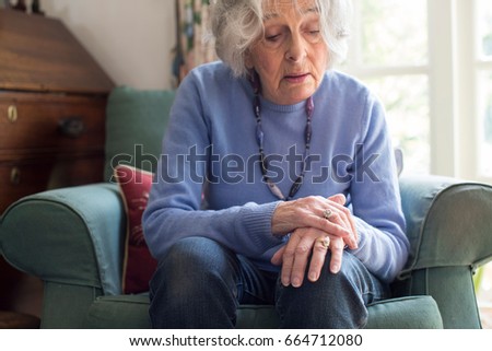 Senior Woman Suffering With Parkinsons Diesease Royalty-Free Stock Photo #664712080
