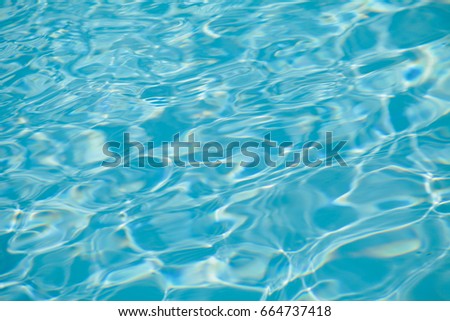 Hotel swimming pool with sunny reflections,sea wave close up, low angle view,blue water background.