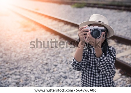 Little asian girl with retro hat taking photo with railway background, Concept of photography or hobby