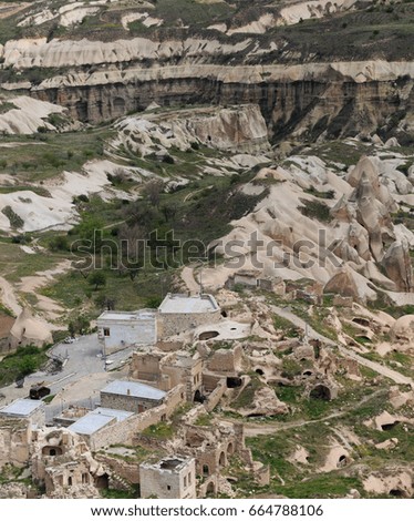 Vertical shot of Cappadocia landscape with rock formations  and some stone buildings