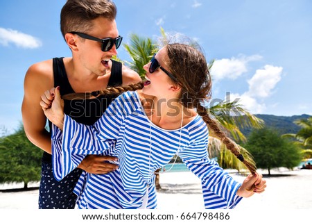 Young pretty couple of young travelers having fun and making selfies in tropical romantic vacation, holidays in paradise island, summer relax. Looking to each other and smilling.