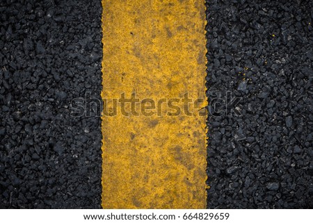 Top view of an asphalt surface texture with single yellow line for decorative
