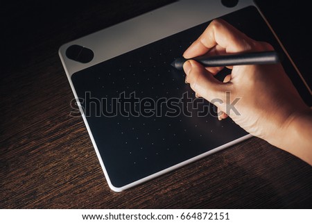 Unrecognizable woman working from home writing on graphic tablet