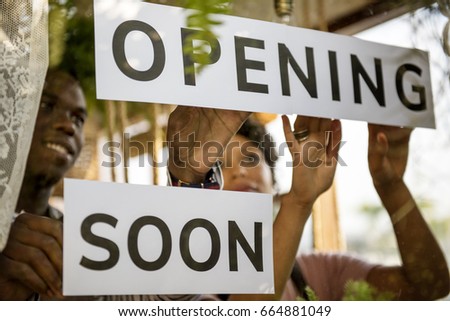 Couple Showing Opening Soon Paper Sign