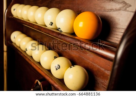 Balls for pool billiards on the shelf / billiard balls for American billiards / balls for Russian billiards / colored or white balls for billiards on a wooden background. Close-up photo. Soft focus.