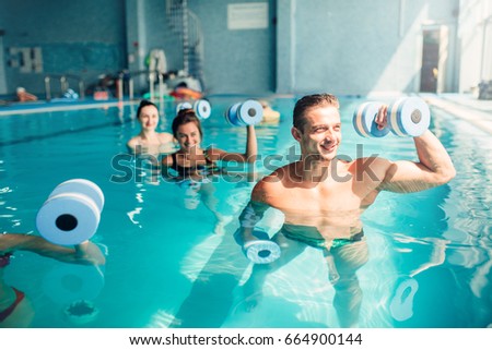 Women aqua aerobics traninig with dumbbells Royalty-Free Stock Photo #664900144
