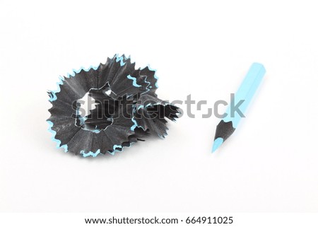 blue pencil and shavings on white paper background