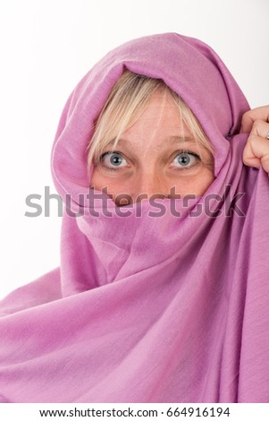 beautiful european mid aged woman hiding her face behind a shawl - studio shot on white background