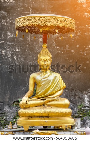 The golden Buddha image with umbrella and flare from the photo corner.