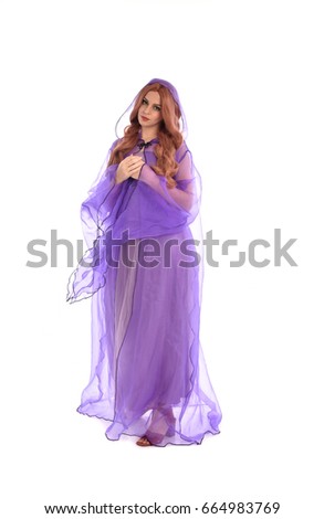 full length portrait of a lady wearing a purple fantasy costume cloak, standing pose isolated against a white background.