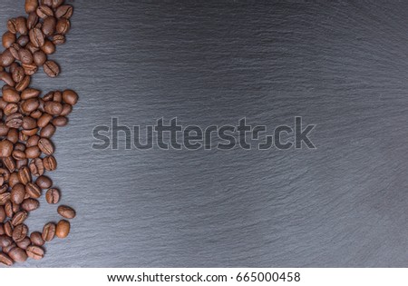 Coffee beans on black background of slate or stone background with copy space. Top view