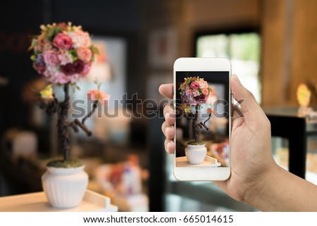 Use a smartphone to take a picture. Send pictures for sale on the web, sell pictures online. Behind is the atmosphere in the coffee.