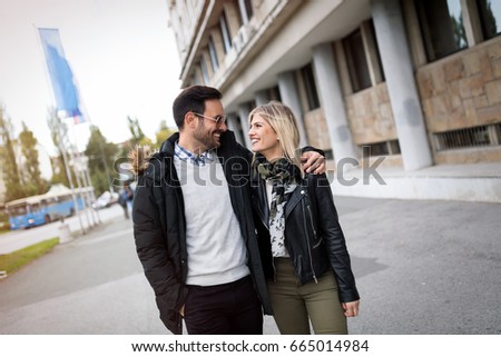 Young cute couple walking together on street