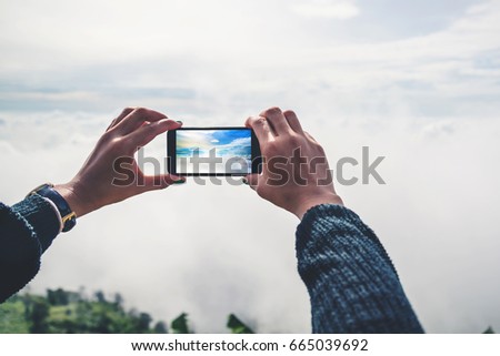 hand for women Photography with mobile phones Mountain view Fog Mist. On the mountains, the morning atmosphere.