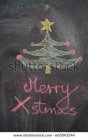 Christmas tree with Merry Xmas writing drawn with white chalk on blackboard