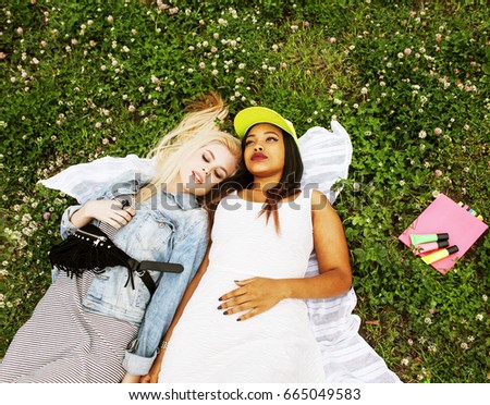two young pretty teenager girls best friends laying on grass mak