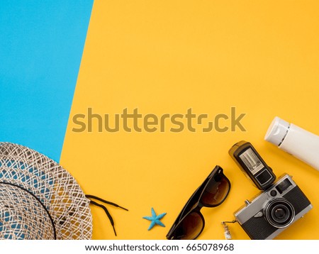 Summer Background, Summer holiday concept, Travel Concept with Untidy props are Sunscreen, Glasses, Camera, sea animal and hat on blue and yellow background.