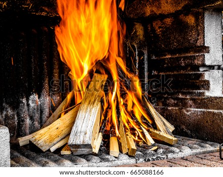 Preparation of a BBQ - wood piled up - flames reaching the top