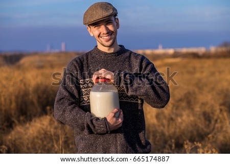 Happy smiling man with milk in the field