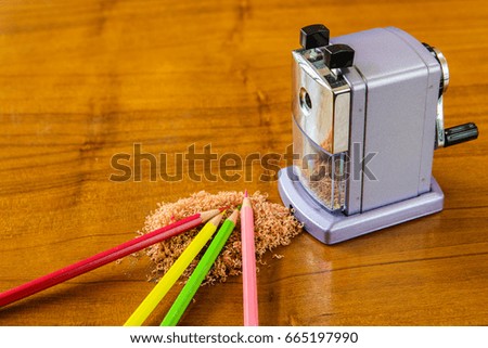 Colorful of crayon and sharpener on wooden table.