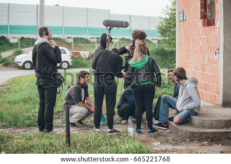 Behind the scene. Film crew team filming movie scene on outdoor location. Group cinema set