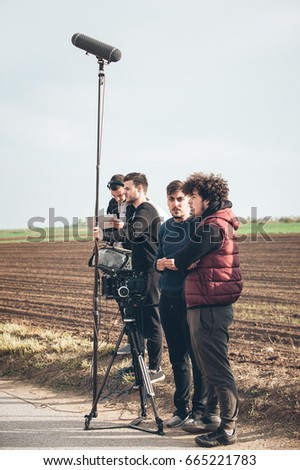 Behind the scene. Film crew team filming movie scene on outdoor location. Group cinema set