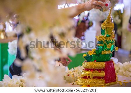 Pouring water or showering or watering buddha with water and incense and flower in Songkran festival (water ceremony in thai's Happy New Year