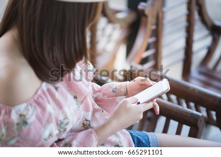 young woman sitting and using mobile phone