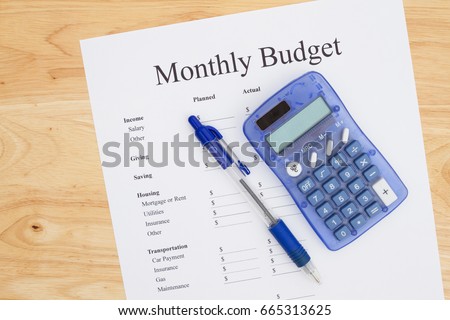 Creating a monthly budget, A print out of a monthly budget with pen and calculator on a desk Royalty-Free Stock Photo #665313625