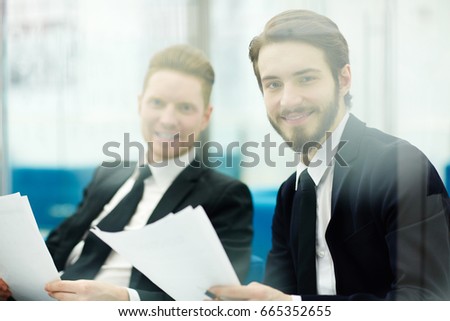 Two traders or bankers with papers looking at camera