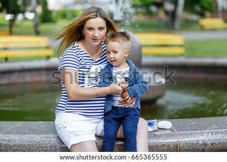 Pregnant woman walking with her son outdoors