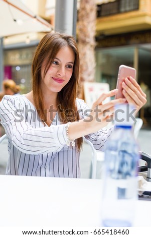 young woman taking a photo in a bar