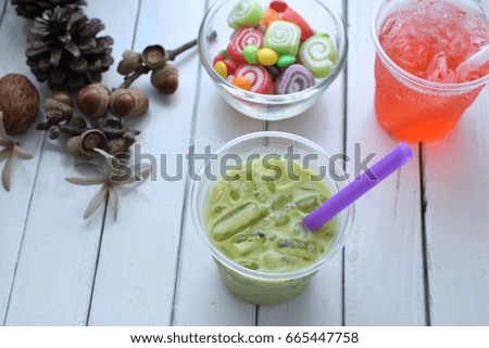 Milk green tea in plastic glass and on white wood  table.
