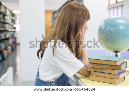 Portrait of a student girl studying at library.