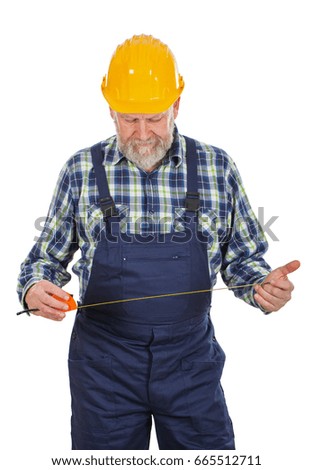Picture of an elderly builder with construction instruments in his hands posing on isolated background