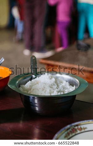 Steamed rice with steam in stainless steel bowl at tourist stop restaurant in North Sikkim, India.