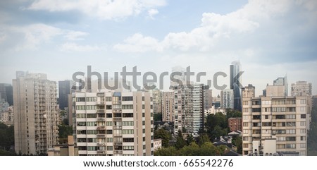 Colored sky with clouds against trees amidst buildings in city