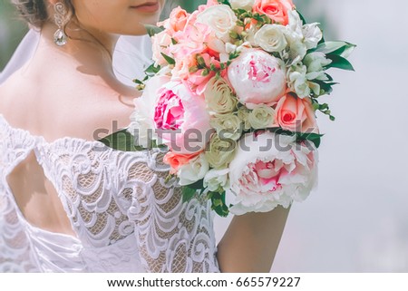 brides bouquet of peonies, roses in hand