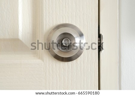 Metal stainless steel knob on white door.